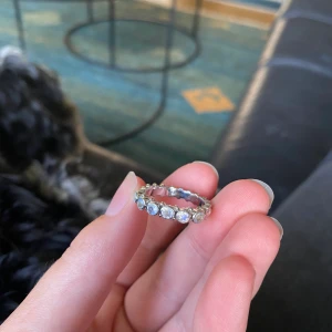 Kum kum ring silver - KumKum ring i silver med silvriga stenar, ser helt ny ut, väldigt bra kvalite, inga rostningar eller missfärgningar!  Strl 15 och jag bär den på mitt ringfinger.  Original pris 899kr
