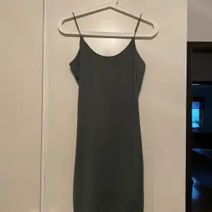 En klänning från BikBok i en jättefin grön färg. Klänningen slutar ungefär mitt på låren och har tunna axelband. Endast använd vid ett tillfälle så den är i väldigt bra skick! 