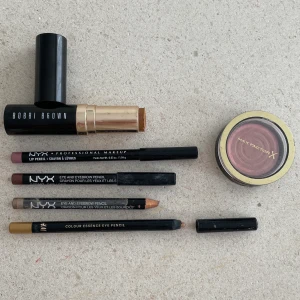 Sminkpaket Bobbi Brown foundationstick contour läppenna eyeliner Nyx rouge maxfactor - Sminkpaket med 1 x Bobbi Brown foundationstick (contour) i ”Warm almond”. 1 x mörkrosa läppenna Nyx. 2 x bruna ögonpennor Nyx. 1 x guldig ögonpenna H&M. 1 x rosa rouge MaxFactor. Använda.