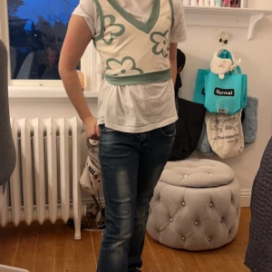 Blommig t-shirt - En grön och vit tröja som är ganska koder vid magen.❤️