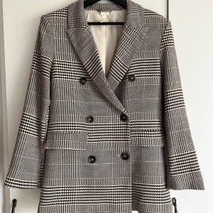 Dubbelknäppt kavaj - En härligt mönstrad dubbelknäppt kavaj från H&M. Använt fåtal gånger så den är i nyskick. Storlek 32 men passar även 34-36. Hör av dig vid intresse!