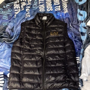 EA7 väst svart  - Säljer min fina EA7 väst pga att den är för liten för mig.  Den är som ny , superfint skick o inga hål eller problem , köpte den i somras så har inte haft den länge. Liten i storleken