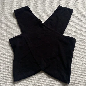 Topp - Svart korsad superfin topp från Nelly. Passar perfekt till fest eller andra tillfällen. Köpte för längesen men har aldrig kommit till användning.💕💕Köparen står för frakt!