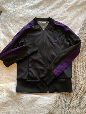 Adidas jacka - Svart lila står att den är st40 men är som en S/Xs andvänd men i mycket fint skick ❤️ kunden betalar frakten 
