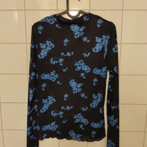 Topp - Topp från Lindex i mesh med blått blommönster. Köparen står för frakten 