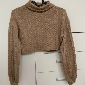 Brun kort långärmad tröja - En kort Brun ganska varm långärmad. Tjockt tyg!  Använt 2 gånger!  Längd: 30cm Bred: 43cm