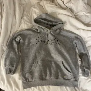 En grå hoodie i märket superdry. Storlek 38/M