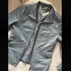 Tajt skinnjacka  - Säljer denna jätte snygga skinnjackan. Väldigt fin färg och bra passform men den är tyvärr för kort i armarna på mig. Köpt secondhand men i väldigt bra skick. Endast provad av mig. Mått finns på sista bilden. Mått F är 59cm 