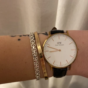 Daniel Wellington klocka  - Säljer min klassiska Daniel Wellington klocka med guld detaljer och svart skinnband. Köpt för 1200kr.