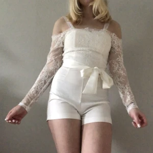 Vit jumpsuit - Jättefin jumpsuit från Dennis Maglic/DM Retro för 700 kr. Endast använd en gång. Banden över axlarna har jag själv sytt fast för att den skulle sitta bättre på mig, men de går såklart att ta av. Perfekt för dig som inte vill ha klänning på studenten!