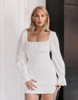 Adoore klänning (Boho dress) - Storlek: 34 (XS) Smockad nederdel Ovandel i broderie anglaise Fodrad byst med knytband Fyrkantig ringning med resår Långa ärmar med volang och knytband  Nypris: 1 495kr