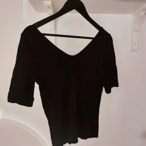 Urringad tröja - Tight tröja med halvärmar och mjuk V-ringning fram och bak. Lite kortare i midjan.