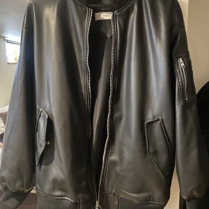 Bomberjacka i PU med detaljer - Svart bomberjacka i PU, detaljer på arm och ryggtext. Storlek L från bershka men skulle säga liten i storlek, lite använd🥰