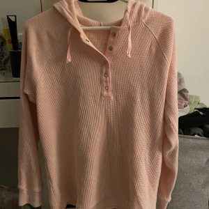 Rosa hoddie  - Typ ribbad oanvänd rosa hoddie i strl M, jätteskön. Har knappar, luva och snören. 40kr+frakt