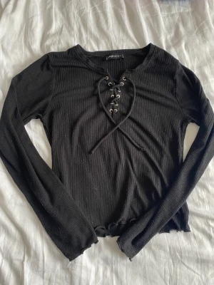 Långärmad topp - En långärmad topp med snörad detalj på framsidan🖤 ribbat material. 