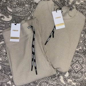 Stronger set beige M - Säljer ett beiget Stronger set i storlek M som aldrig kommit till användning. (Både tröjan och byxorna är i storlek M) ribbstickat material.  Ordinare pris 1400kr.  Kontakta mig för intresse/frågor!