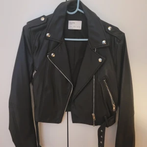 Skinnjacka/bikerjacka från Bershka - En skinnjacka i läder/skinnimitation ifrån Bershka som är i bra skick och knappt använd, i storleken S svart. Endast om du ska köpa jackan köparen står för frakten. 
