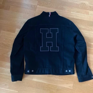 Tommy Hilfiger Jeans Jacka  - Tommy Hilfiger Jeans Jacka svart  Storlek M sitter som S/M  Pris 299kr  Modellen är 179 o h väger 84kg, har vanligtvis på sig M i tröjor och 33 i byxor