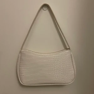 Vit axelväska - Säljer nu denna snygga axelväska med "krokodil mönster". Enkel att ta med och passar till allt🥰