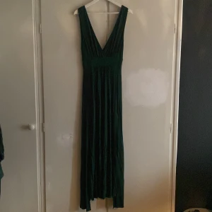 Långklänning  - Långklänning mörkgrön, med hög slitz på båda sidor, storlek M men skulle utan problem passa stl L, aldrig använd