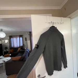 Stone Island knitted Roll Neck - Säljer en grå turtleneck/roll neck från Stone Island i storlek S. Den har knappt använts iom att den blir för stor i kroppen för mig (182 cm / 58 kg) men passar bra i armar och längd.   Använd 3-4 gånger, retail 3100 kr  Swish + spårbar frakt!