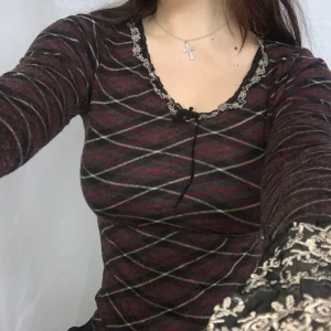 rutig topp med spets - cool och fin rutig topp i rött, grått, svart och beige med spetskant och en liten rosett i ringningen:-* från japanska designermärket l’est rose, köpt på buyee. i ull pch japansk storlek m, motsvarar typ xs. jättebra skick. skriv för mått eller frågor <3