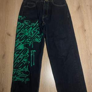 Mörk blåa/ svarta  jeans men grönt graffiti tryck på benet. As coola! De är köpta från Instagram säljare för något år sedan. 