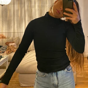 H&M Svart tröja  - En tjock svart tröja med tjockt glansigt material.