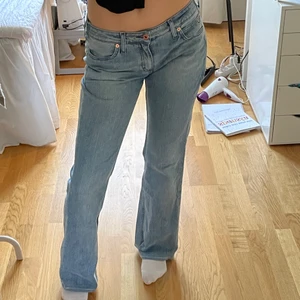Lågmidjade jeans 🤍 - Lågmidjade jeans i en ljusblå tvätt från tommy hilfiger köpta secondhand! Från början en w31/l34 men omsydda till en w28/l32. Midjemåttet är 78 cm och innerbensmåttet är 79 cm. Enda defekten syns på bild två, bakre remmen är borttagen. 🤍🤍