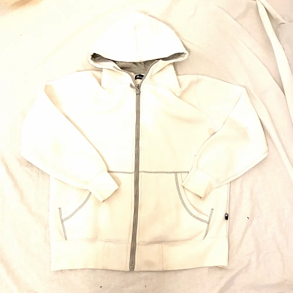 Vit zip hoodie med gråa detaljer, snöret är bort dock! Från 4Code i storlek L men sitter som en Medium. Hoodies.