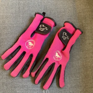 Rishanskar - Lilarosa små ridhanskar, passar mig som 12 åring men lite små, lite grepp har kommit av men kan fortfarande användas, inga hål eller något sån ifrån greppet, läder isch på greppet men fint tygg på handsken🐴