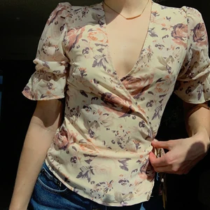 Helt ny blus från NA-KD - En helt ny blus med blomprint från NA-KD i storlek XS. Aldrig använd. Säljes pga för stor i bysten (jag har A/B kupa). Superfint print med blommönster på beiget silkestyg.