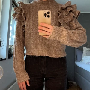 Stickad tröja med volang  - Stickad tröja med volang från Gina Tricot i bekvämt material, akryl & polyester. Storlek S. I princip oanvänd. 