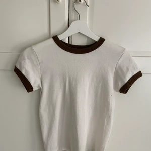 T-shirt ifrån Brandy Melville🤎 - Söt tröja ifrån Brandy Melville!! Köpt ca 6 månader sedan men har bara använts ksk 1 gång. Snygg till sommaren!😍
