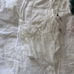 Vit spetsbody Asos - Hej! Säljer denna oanvända spetsbodyn från asos. Banden är justerbara och prislappen är kvar. Hör av er vid ev frågor. Köpaten står för frakten🥰 