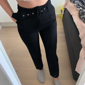 Snygga kostymbyxor med bälte - Svarta kostymbyxor från NA-KD med bälte i midjan. Supersnygga och sparsamt använda. Passar 36, inte större men eventuellt mindre. Ganska ”stel” passform, dvs inte mycket stretch.