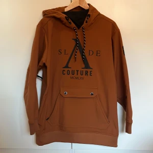 Snowboardjacka - Snygg snowboardjacka som ser ut som en hoodie. Vind och vattenresistent. Två fickor på magen knäpp och dragkedja. Högt skydd vid halsen. Stor luva. Mudd i nedre kanten och på ärmslut. Passar tonåring 14-17år eller tjej upp till strl M. Oversize fit.