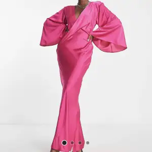 En rosa långklänning (st 36) i satin med slits, öppen rygg samt utsvängda armar. Klänningen är från asos men är slut på hemsidan. Har använts en gång. Jag är en och 173 och i vanliga fall har jag 38 men klänningen sitter bra på mig. 