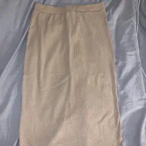 Brun kjol med en liten slits där bak vid benen. Köpt för ca 2 år sedan men har aldrig använt den.