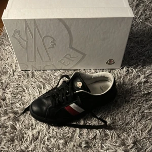 Moncler skor svarta - Jag har haft dem sen somras och på ena skon finns det ett litet svart märke.