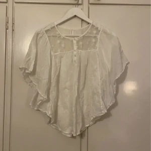 Vit blus - En kortärmad vit blus med spetsdetaljer, nästan helt oanvänd!