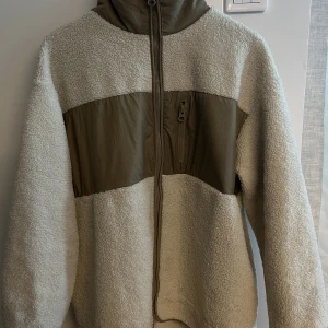 Vårjacka  - Fin vårjacka från H&M i teddyliknande material med beigea detaljer. Perfekt nu till våren, passar allt från XS-L beroende på hur man vill ha modellen 