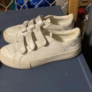 Sneakers från Nø Name - Sjukt snygga sneakers med kardborreband, lätt silver skimriga detaljer. Knappt använda då de är för små för små. Nypris 1200kr