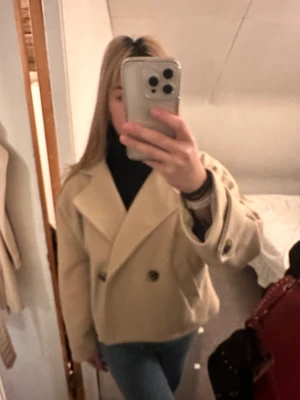 Beige kappa - En beige kappa i storleken S. Helt oanvänd därav bra skick. Säljer pga inte riktigt min stil 