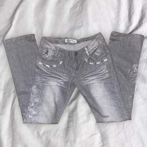 lågmidjade jeans med fina detaljer och fin grå glittrig färg som tyvärr är för små för mig :/ midjemått: ca 83 cm. innerbenslängd: ca 84 cm. buda gärna!!💋