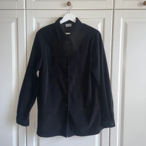 Skjorta i mocka - Svart skjorta i mockaliknande tyg. Fin kvalitet med snygga detaljer och sömmar. Fin som overshirt!