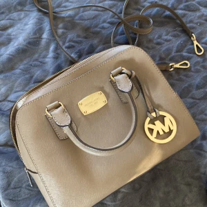 Söt liten väska - En mörkbeige väska, perfekt för få plats med allt man behöver en utekväll. Väldigt oklart om äkta el inte. 