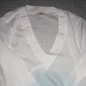 Blus  - En vit långärmadblus i tunt matrial. Använt många gånger men är i bra i skick. 