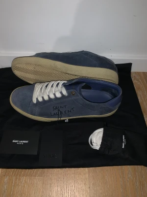 Saint Laurent sneakers marin blå - Hej! Jag säljer mina saint Laurent skor eu 40 men d är stora i storleken köpta från vitkac. De har aldrig blivit använda och är i toppskick. Certifikat, dustbag, extra snören och kvitto ingår. Fraktar och möts upp i Gbg. Dom vid frågor om allt