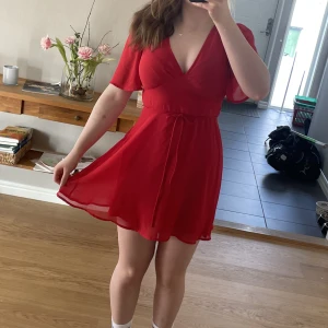 Röd sommarklänning  - Röd sommarklänning i lätt tyg. Köpt på veromoda i strl M. Snöre i midjan som knyts antingen fram eller bak.  Köpare står för frakt